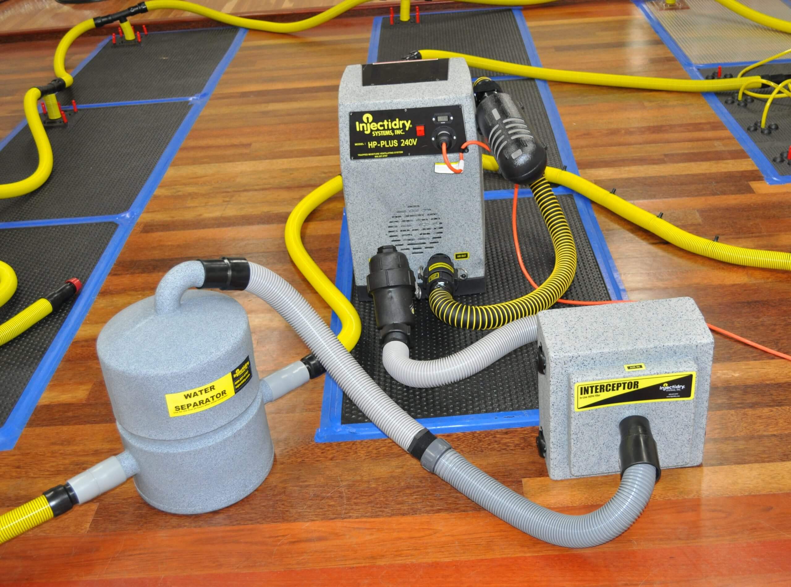 Water getting extracted from hardwood flooring after a flooding incident. Water damage cleanup near me