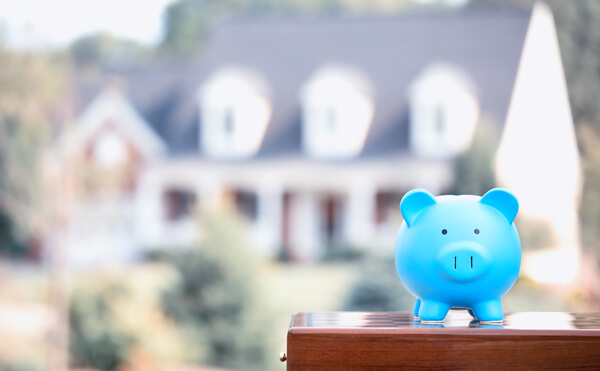 Piggy bank in front of home. Piggy bank in front of home.