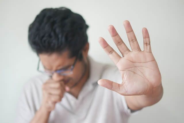 A man sneezing and feeling unwell as a result of allergies. A man sneezing and feeling unwell as a result of allergies.