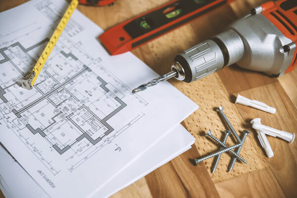 Various tools and house drawings on a table. Various tools and house drawings on a table.